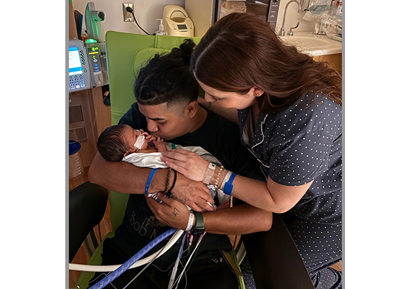 Draven Chouinard being held by his parents in the NICU while recovering from CDH treatment