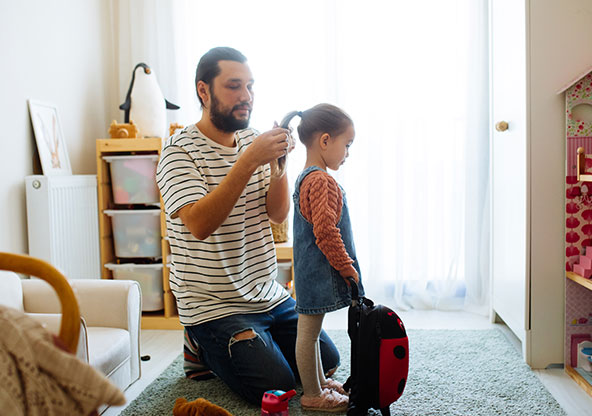 Dad fixing daughters hair for school