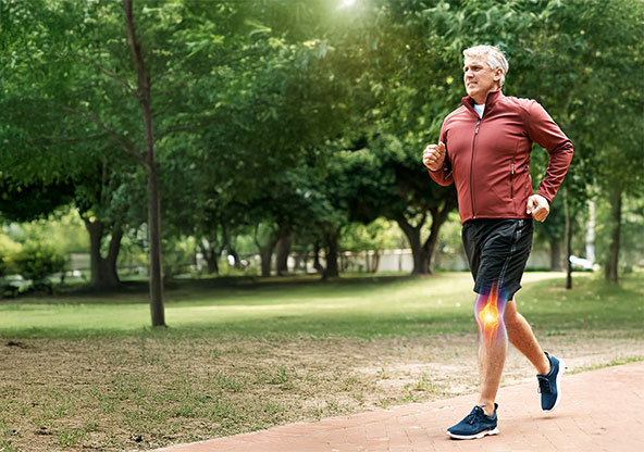 knee replacement surgery promo: shows man in red shirt, black shorts and navy shoes running from right to left. His knee bone is highlighted signifying he recovered with a stronger joint.