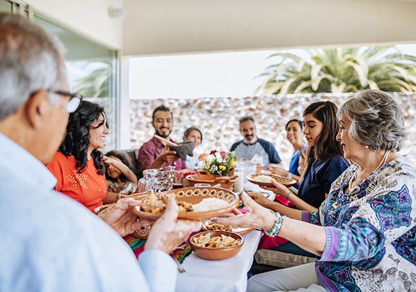 A multi-generational Latino family enjoying dinner together